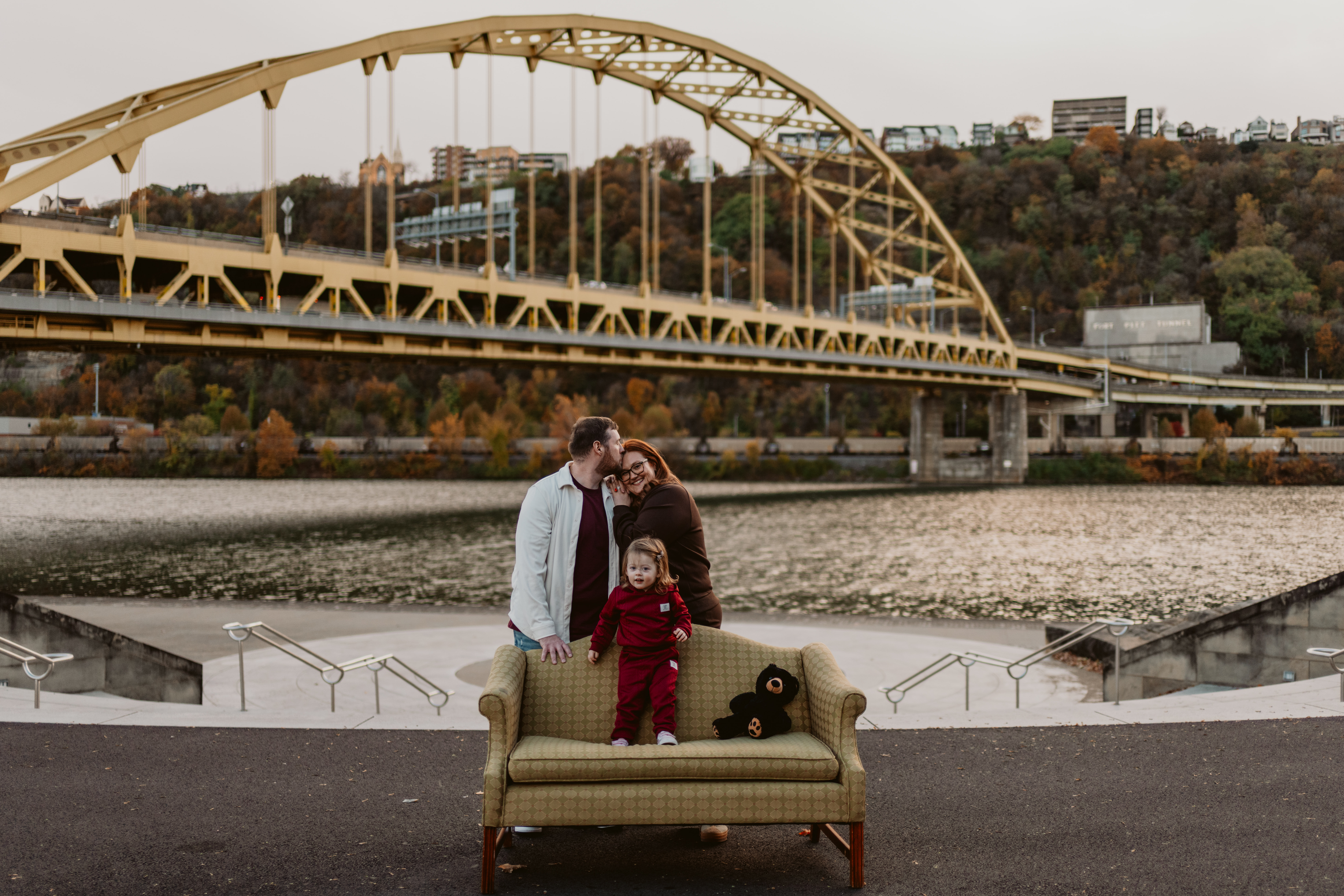 Family sitting together on a vintage couch at Point State Park during a Pittsburgh photo session